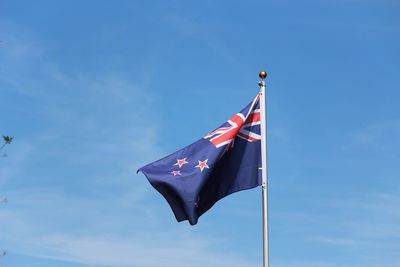 Low angle view of flag flags against blue sky