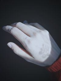 Close-up of human hand against black background