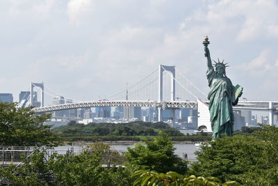 Statue of bridge against cloudy sky