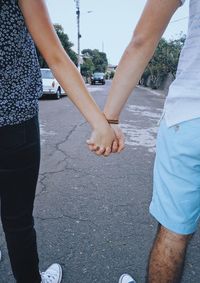 Low section of couple holding hands