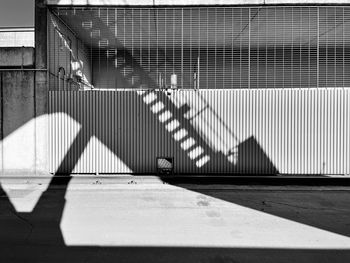 Shadow of railing on footpath against building