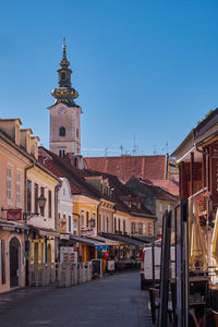 Buildings in city against clear blue sky