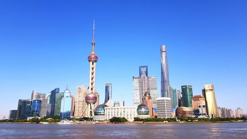 View of buildings in city against blue sky