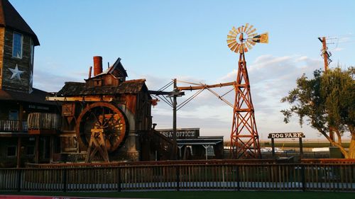 Ferris wheel by bridge against sky