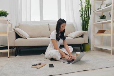 Side view of young woman exercising at home