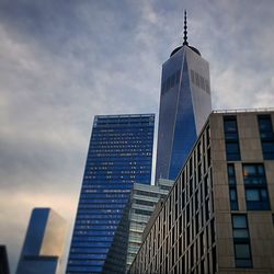 Low angle view of modern building against cloudy sky