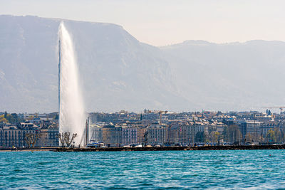 Beautiful view of the water jet fountain in the lake of geneva and the cityscape