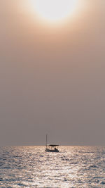 Silhouette boat sailing in sea against sky during sunrise in pari island, indonesia