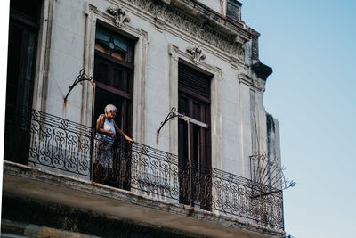 Low angle view of woman standing against building