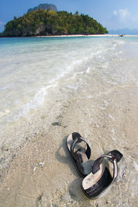 High angle view of flip-flops on shore at beach