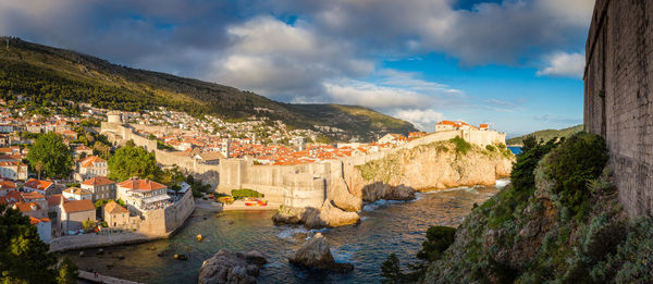 Panoramic view of buildings in town against sky