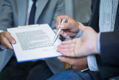 Midsection of businessman signing contract