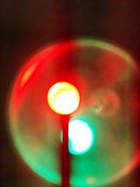 Defocused image of illuminated lights against sky at night