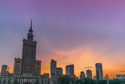 Buildings in city against sky during sunset