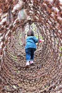 Rear view of girl in outdoor play equipment