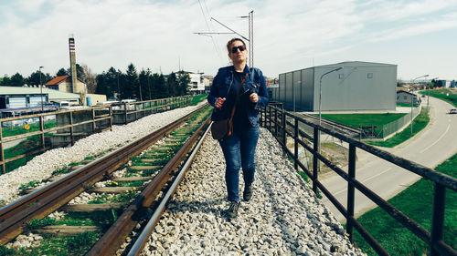 Full length of woman walking by railroad track