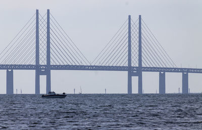 View of suspension bridge over sea against clear sky