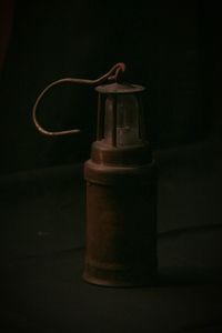 Close-up of old bottle on table against black background