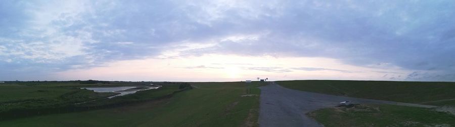 Road amidst land against sky during sunset