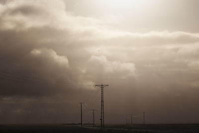 Electricity pylon against sky during sunset