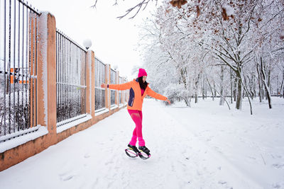 Winter workout, exercising in cold weather. winter fitness trening kangoo jumps. sporty woman in