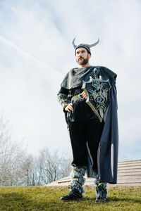 Portrait of man standing on field against sky