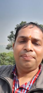 Close-up portrait of man against sky