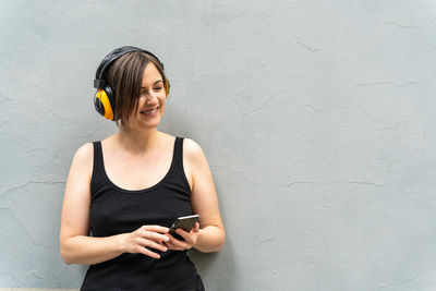 Portrait of young woman suffering from wall