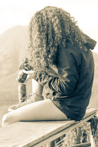 Side view of woman sitting outdoors