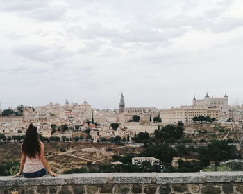 Rear view of woman standing in front of cityscape