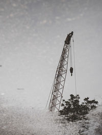 Low angle view of crane against sky