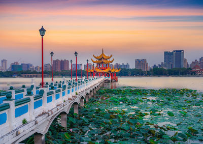 View of tower and buildings against sky during sunset