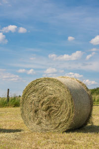 Hay bales on field against sky