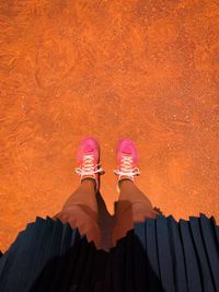 Low section of person standing on pink umbrella