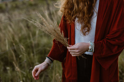 Midsection of woman holding plant