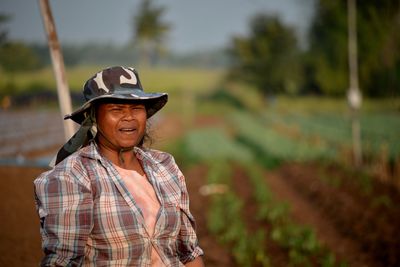 Woman wearing hat while standing at farm