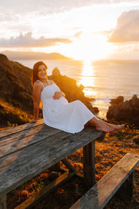 Pregnant woman against an oceanic landscape at sunset in galicia, spain