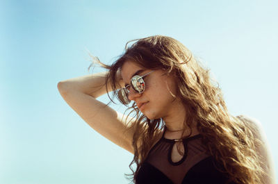 Portrait of young woman against blue sky