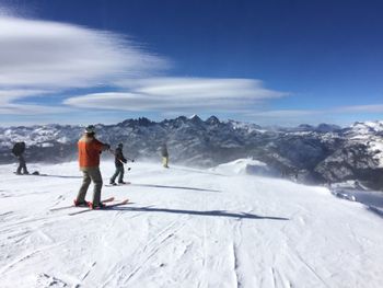 People skiing on snow covered field 