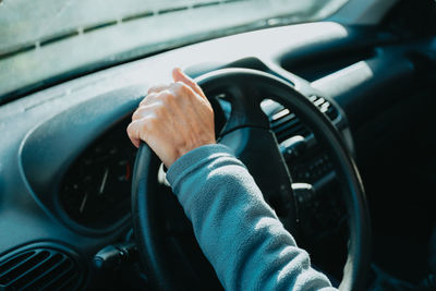 Cropped hand of man driving car