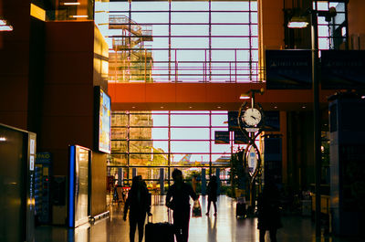 People walking on illuminated modern building in city