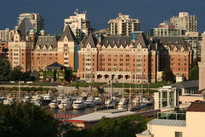 Boats moored in river against buildings