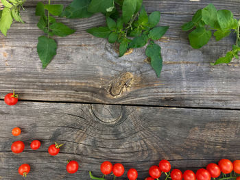 Directly above view of fresh cherry tomatoes and leaves on table