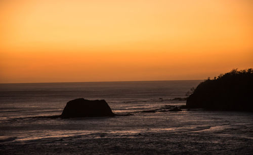 Scenic view of sea against orange sky