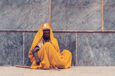 Portrait of woman sitting on wall