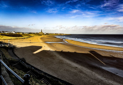 Deep shadows creep over the long sands at tynemouth, england