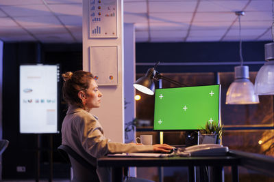 Side view of young woman working in office