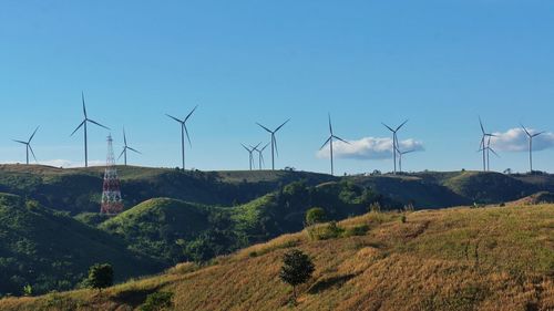 Windmills on field against sky