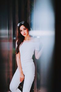 Portrait of smiling young woman standing at home