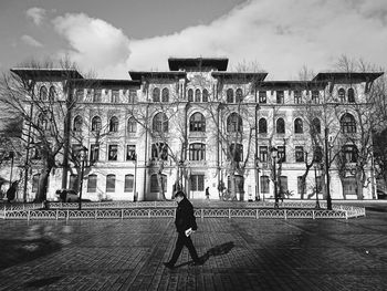 Man walking on street against buildings in city